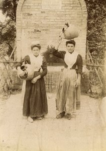 Zwei junge Frauen in traditioneller Kleidung mit Terrakottagefäßen am Brunnen, Marken, Italien, ca. 1910