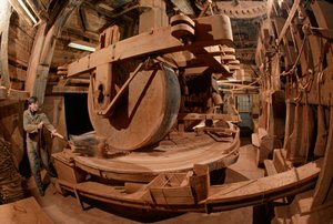 Ein Mann mahlt Kakaobohnenschalen zu Tierfutter in einer 100 Jahre alten Mühle. Ooievaar-Mühle