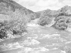 Ein starker Fluss/Bach durchschneidet die Landschaft