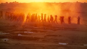 Arbeiter tragen Materialien bei archäologischen Ausgrabungen in Abydos. Staub und...