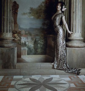 Halbnackte Frau im silbernen Kleid mit Rautenmuster in klassischem Interieur