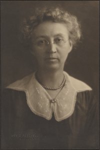 Porträt einer Frau mit Juwelenbrosche von Louis Fleckenstein