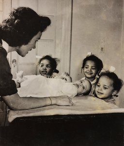 Krankenschwester Henry Street hilft drei afroamerikanischen Mädchen in Harlem, New York City von Luigi Leoni