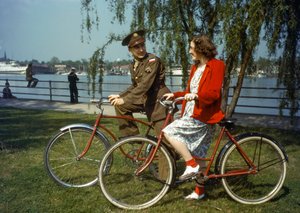 Sitzend auf Fahrrädern in der Nähe eines Hafens, US-Armeeoffizier flirtet mit einer jungen Frau auf Trinidad