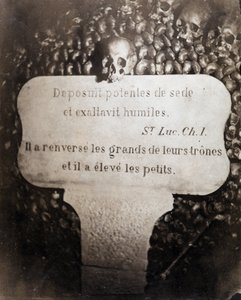 Die Beinhäuser der Katakomben von Paris. Peter trägt ein Zitat aus Kapitel 1 des Evangeliums von Lukas (Deposuit potentes de sede et exaltavit humiles. Auf Französisch: Er stürzte die Großen und erhob die Kleinen) von Nadar