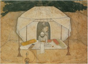 Balwant Singh sitzt schreibend auf einem Feldbett