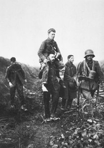 Ein deutscher Infanteriesoldat mit verletztem Bein wird von englischen Kriegsgefangenen aus der Schlacht getragen