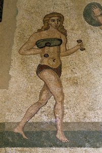 Junge Römer bei körperlichen Übungen. Sie tragen einen Lendenschurz um die Nieren und ein Strophium (Vorläufer des BHs) auf der Brust. Römisches Mosaik des 3. - 4. Jahrhunderts aus der Villa del Casale, Piazza Armerina (Sizilien).