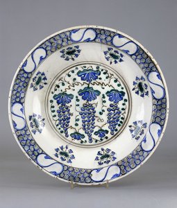 Ein Iznik-Keramikteller, mit einem zentralen Rundel, das drei Traubenbündel und Weinblätter darstellt, ca. 1570 von Turkish School
