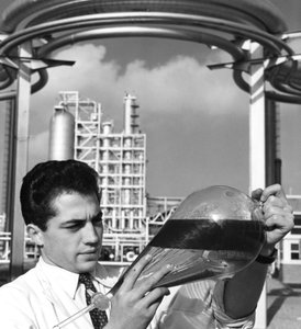 Ein Laborarbeiter hält einen Scheidetrichter mit Öl, Raffinerie Dunkerque, Frankreich, 1950er