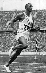 Jesse Owens am Ende des 100m-Laufs bei den Olympischen Spielen in Berlin, 1936