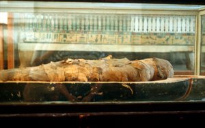 Mumie in Bandagen gewickelt und auf dem Boden eines Sarges liegend, Antikes Ägypten