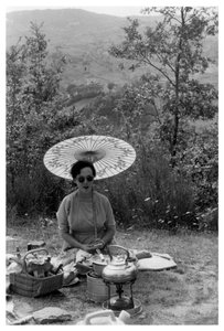 Frau unter einem Sonnenschirm beim Picknick, ca. 1950-1969