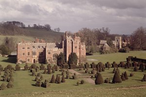 Außenansicht mit Formschnittgarten und Kirche dahinter, Compton Wynyates, Warwickshire, spätes 15. - frühes 16. Jahrhundert