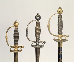 Griffe von drei französischen Schwertern: einer aus Stahl, gebläut und mit Goldgravuren verziert, um 1730; einer aus Stahl, durchbrochen und gemeißelt und der Grund aus mattiertem Gold, um 1760; einer aus gemeißeltem Stahl, gr