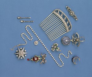 Auswahl an Diamantschmuck: Haarkamm; abgestufte Collet-Halskette; Saphir-Halbmond-Brosche; Email-Karfunkel-Anhänger; Taschenuhr; Sternbrosche