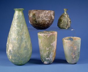 Im Uhrzeigersinn von links: birnenförmige grüne Glasflasche, Sassanidisch, 3.-7. Jahrhundert n. Chr.; hellbernsteinfarbene Glasschale, Sassanidisch, 5.-6. Jahrhundert n. Chr.; islamische grüne Glasbirnenflasche, ca. 8.-12. Jahrhundert n. Chr.; zwei islamis von Unbekannt