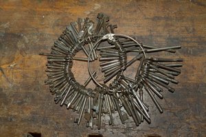 Großes Bündel alter Schlüssel auf Ring auf Holzschreibtisch von Unbekannt