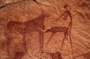 Felskunst, Vorgeschichte: Felsmalerei einer Kuh, eines Kalbs und einer Figur (Bogenschütze) in einem verzierten Schutzraum im Uweinat-Massiv, Ägypten. (Zeitraum von 8000 bis 3000 Jahre v. Chr.). Fotografie