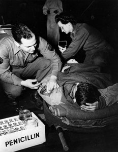 Zweiter Weltkrieg (1939-1945): Luxemburg Februar 1945: In einem Evakuierungskrankenhaus der US-Armee verabreicht ein Sanitäter (Krankenschwester) einem verletzten Soldaten Penicillin, um eine Infektion zu vermeiden, während eine Krankenschwester ihn für ei