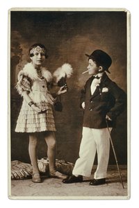 Zwei Kinder, die als Erwachsene verkleidet sind, in der Mode der 1920er Jahre. Das kleine Mädchen trägt ein Outfit für den Charleston, und er im Anzug, Melone und Zigarette. Fotografie von Unbekannter Künstler