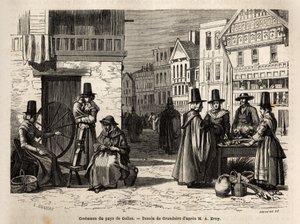 Eine Straße in Wales, mit Einheimischen in traditionellen Kostümen und alltäglichen Aktivitäten: eine Familie und Frauen, die Wolle mit Rädern spinnen. Gravur zur Illustration einer Reise in das Land Wales, 1862, von Alfred Erny, in „Le tour du monde, nouv