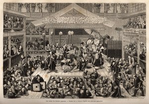 Eine Bühne des japanischen Theaters in Yokohama, mit drei Galerien für die Zuschauer; die Schauspieler spielen auf einer hohen Bühne, jeder begleitet von einem Mann, der einen langen Stock hält, an dessen Ende eine Kerze befestigt ist; während der Aufführu