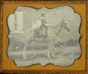 Junge mit Hut auf einem Pferd