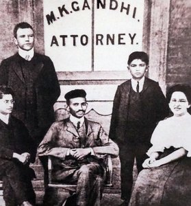 Mahatma Gandhi sitzt mit vier Begleitern vor seiner Anwaltskanzlei in Johannesburg, Südafrika