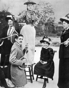 Marcel Proust, inmitten einer Gruppe junger Frauen, spielt Gitarre auf einem Tennisschläger am Boulevard Bineau in Paris