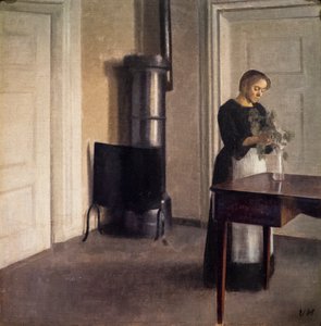 Interieur mit einer Frau, die Blumen in einer Vase arrangiert