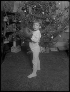 Unidentifiziertes Kind vor einem Weihnachtsbaum mit Boxhandschuhen, 1915-16