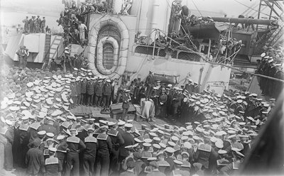 Seeleute drängen sich um den australischen Premierminister The Hon William Morris (Billy) Hughes, als er sie auf dem Deck der HMAS Australia in der Werft in Devon, England, anspricht, 21. Mai 1916 von Australian Photographer
