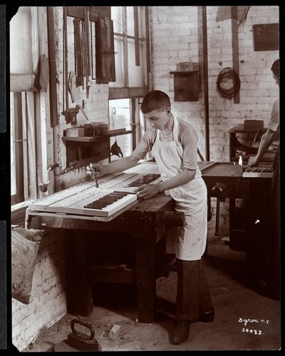 Ein junger Mann arbeitet in der Harrington Piano Co. Fabrik, 1907 (Silbergelatineabzug) von Byron Company