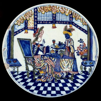 Delfter Porzellanteller mit einer Frau an einem Tisch, bedient von ihrem schwarzen Diener (1705) von Dutch School