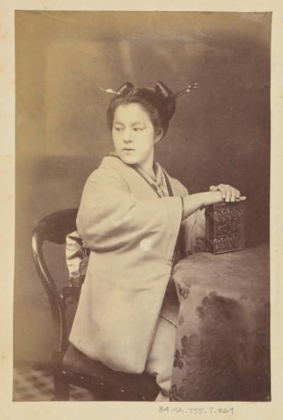 Sitzende japanische Frau mit einem Cartes-de-Visite-Album an einem Tisch von Felice Beato