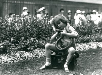 Ein junges Mädchen Betty hält eine östliche Indigo-Schlange, während sie auf einem Lederkoffer sitzt, London Zoo, 1924 von Frederick William Bond