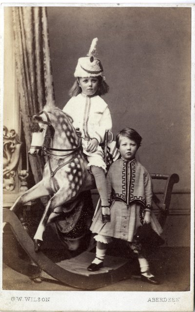 Mädchen mit Hut auf Schaukelpferd mit einem anderen Mädchen daneben von George Washington Wilson