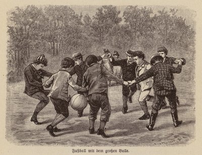 Jungen spielen Fußball mit einem großen Ball von German School