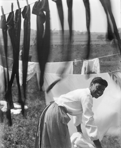 Eine junge afroamerikanische Frau hängt Wäsche zum Trocknen auf in Newport, Rhode Island, ca. 1902 (s/w Foto) von Gertrude Käsebier