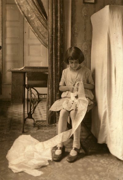 Ein junges Mädchen schneidet Spitze in ihrem Zuhause in New York City von Lewis Wickes Hine