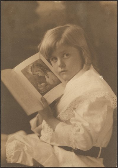 [Porträt eines Kindes, das ein Buch offen hält, um eine ähnliche Illustration zu zeigen] von Louis Fleckenstein
