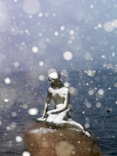 Schneesturm auf der Statue der kleinen Meerjungfrau von Edvard Eriksen, Winter in Kopenhagen, Dänemark, 2022 (Foto) von Sisse Brimberg