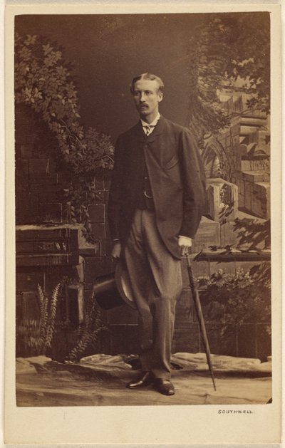 Unbekannter Mann mit Schnurrbart, der einen Zylinder und einen Regenschirm hält, stehend von Southwell Brothers