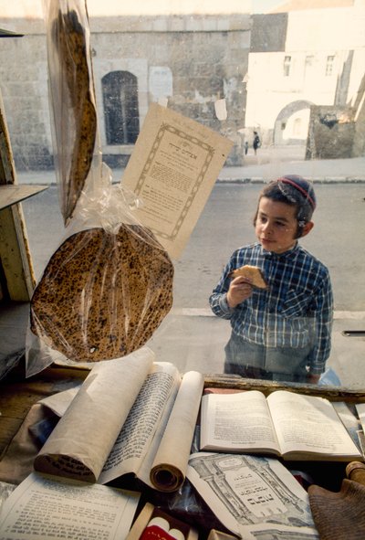 Konservativer jüdischer Junge isst Kuchen und schaut in eine religiöse Buchhandlung von Ted Spiegel