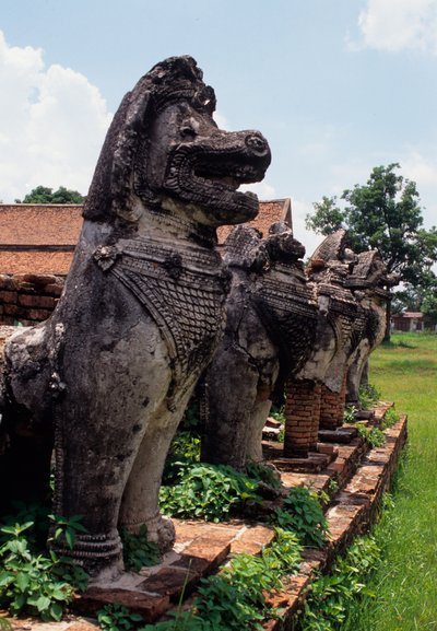 Löwenartige steinerne Wächterfiguren um die Basis der Stupa von Thai School
