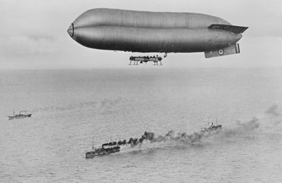 RNAS Coastal Class Luftschiff C23A fliegt über einen Kriegsschiff-Konvoi, ca. 1917 von Thomas E. and Horace Grant Grant