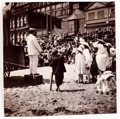 Menschenmenge beobachtet einen Strandunterhalter, um 1905 von Unbekannt