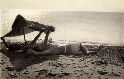 Zwei Frauen liegen am Meeresufer im Schatten eines Handtuchs. Postkarte vom Fotografen an Vincenzo Balocchi gesendet von Vincenzo Balocchi