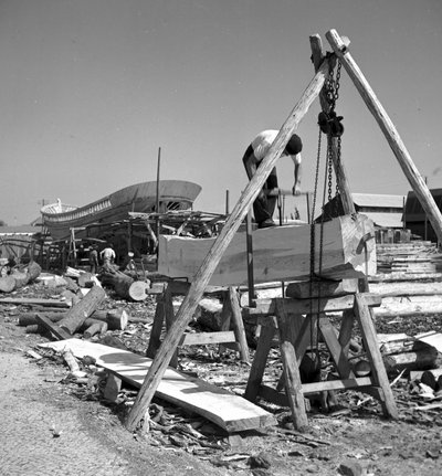 Portugiesische Bootsbauer bauen ein Fischerboot aus Holz mit einer Quersäge von Volkmar Wentzel